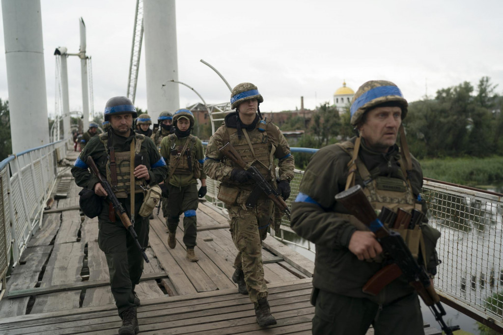 Ukrajinskí vojaci kráčajú cez most v meste Izium v Charkovskej oblasti na východe Ukrajiny. FOTO: TASR/AP