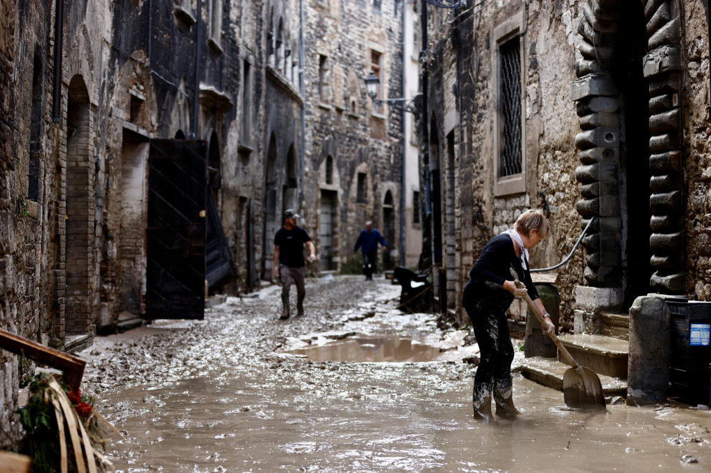 

Ľudia pracujú na uvoľnení cesty po silných dažďoch a smrteľných záplavách, ktoré zasiahli stredotaliansky región Marche. FOTO: Reuters