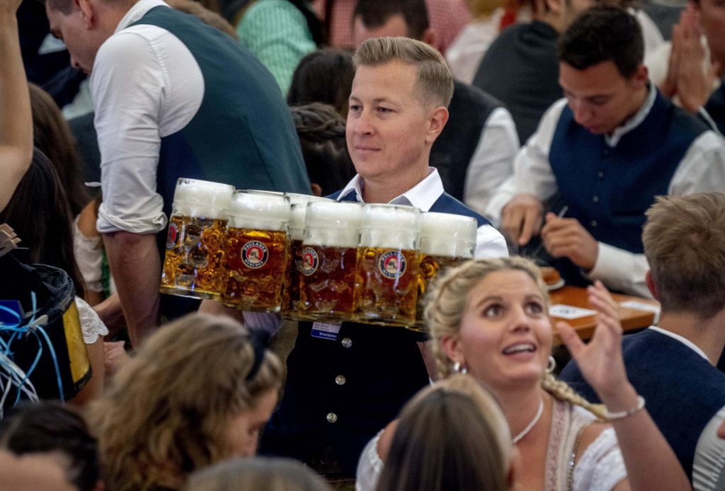Ča&scaron;n&iacute;k nesie piv&aacute; v jednom z pivn&yacute;ch st&aacute;nkov počas otvorenia 187. tradičn&eacute;ho mn&iacute;chovsk&eacute;ho pivn&eacute;ho festivalu Oktoberfest v Mn&iacute;chove. FOTO: TASR/AP