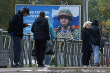 Ľudia pred tabuľou zobrazujúcou portrét ruského člena armády Sergeja Cerkovnija v ruskom Petrohrade. FOTO: REUTERS