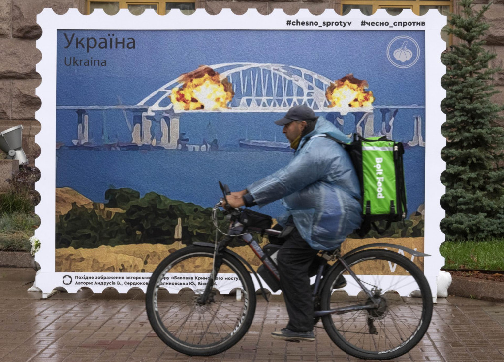Zväčšená poštová známka, ktorá zobrazuje expolóziu krymského mosta spájajúceho Ukrajinu a Rusko v blízkosti kyjevskej radnice. FOTO: TASR/AP