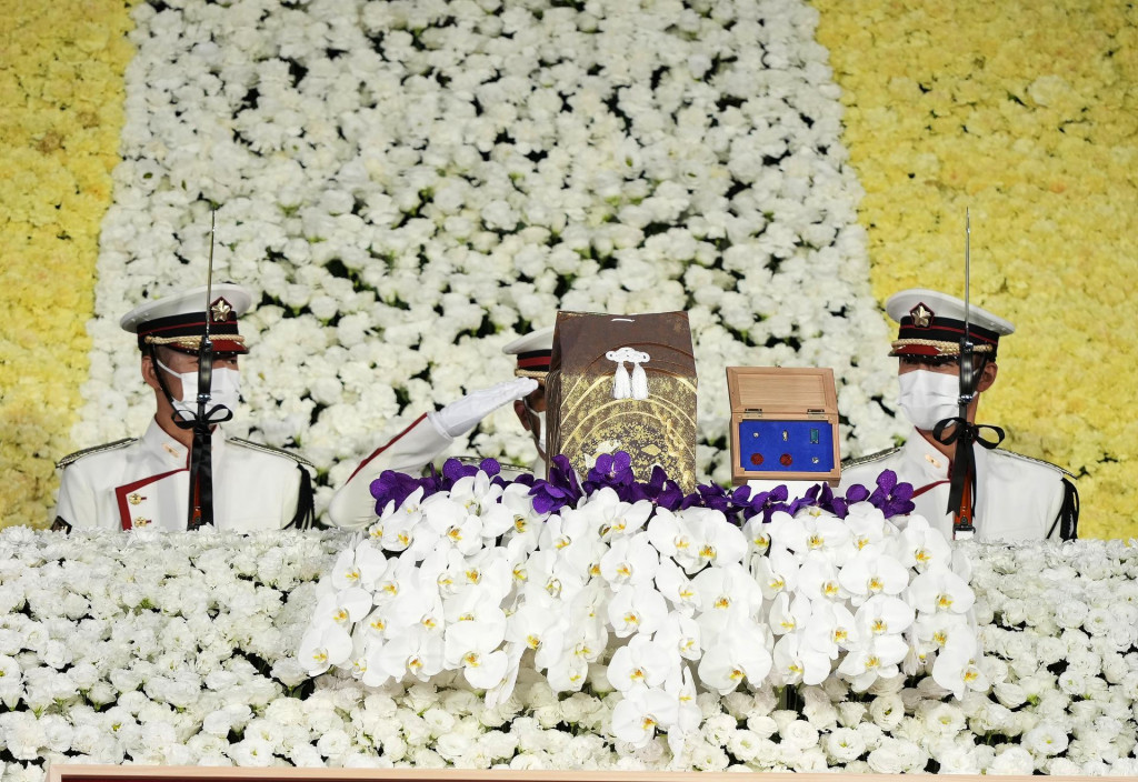 Členovia čestnej stráže salutujú pri urne bývalého premiéra Japonska Šinzóa Abeho počas štátneho pohrebu v hale Nippon Budokan Hall. FOTO: TASR/AP