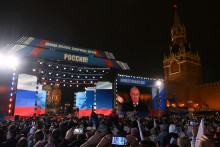 

Diváci počúvajú ruského prezidenta Vladimira Putina. FOTO: Reuters