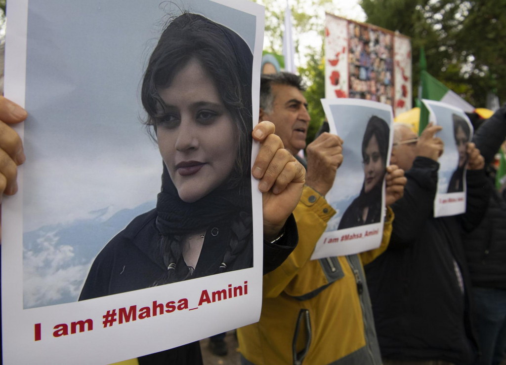 Ľudia držía fotografiu zosnulej mladej Iránky Mahsá Amíníovej počas protestu pred iránskym veľvyslanectvom v Berlíne. FOTO: TASR/DPA