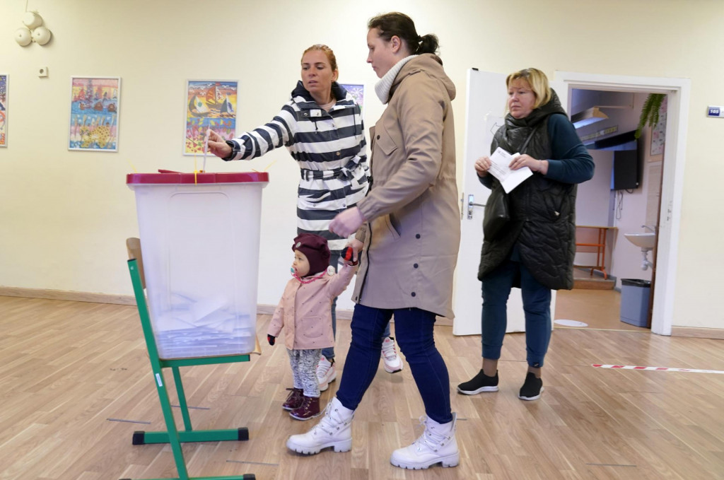 Ľudia hlasujú vo volebnej miestnosti počas parlamentných volieb v Lotyšsku. FOTO: TASR/AP