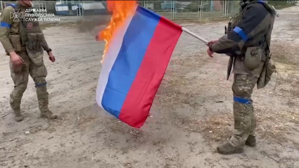 Ukrajinskí vojaci pália ruskú vlajku. FOTO: REUTERS