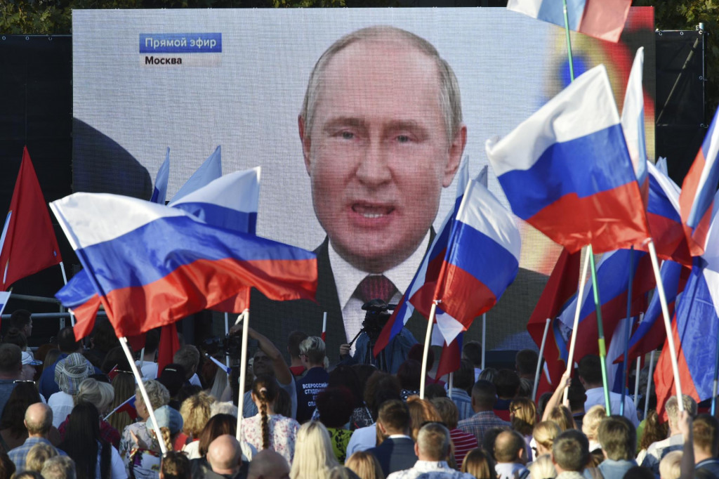Ľudia sledujú na veľkoplošnej obrazovke prejav Vladimira Putina pri príležitosti podpisu zmluvy o pričlenení štyroch okupovaných oblastí Ukrajiny k Rusku. FOTO: TASR/AP