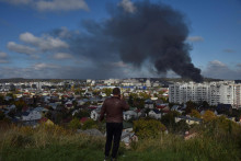 Muž pozerá na dym stúpajúci nad mesto po zásahu ruských rakiet vo Ľvove na Ukrajine, 10. októbra 2022. FOTO: REUTERS