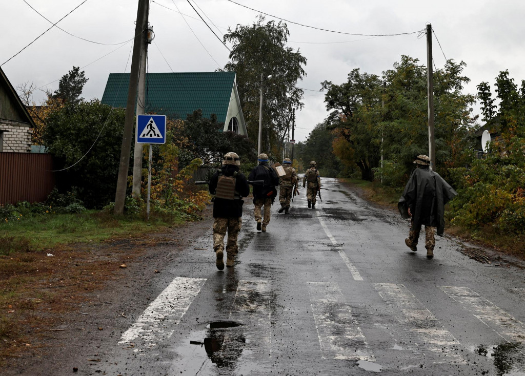 Ukrajinskí vojaci kráčajú po ulici uprostred ruského útoku na Ukrajinu. FOTO: Reuters