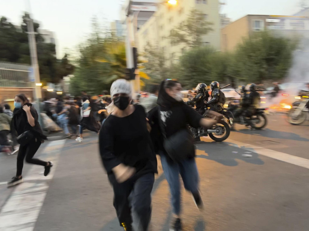 Demonštrantky utekajú pred zásahom príslušníkov iránskych bezpečnostných síl počas protestu v centre Teheránu. Protesty spôsobili nestabilnú situáciu v celom Iráne. FOTO: TASR/AP