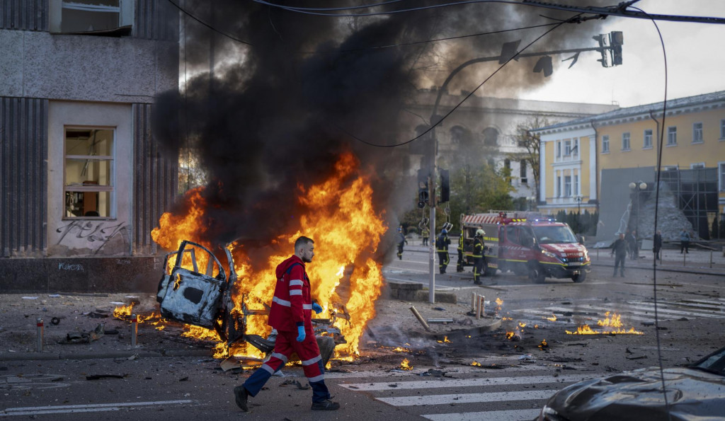 Zdravotník uteká okolo horiaceho auta po ruskom raketovom útoku v Kyjeve. FOTO: Roman Hrytsyna