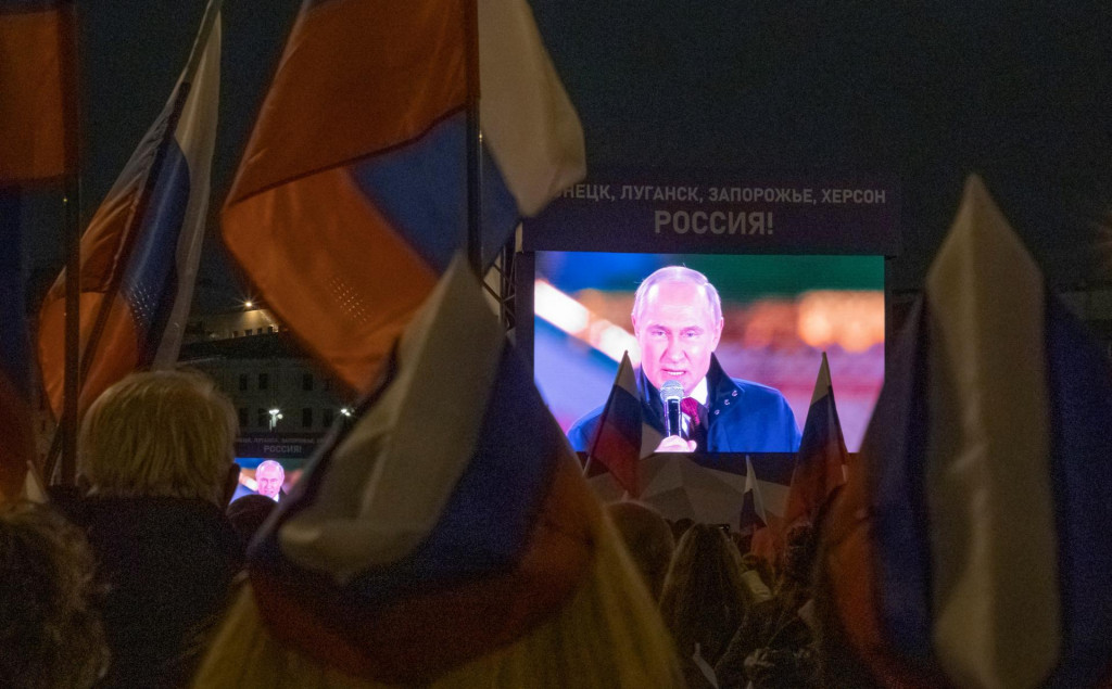 Vladimir Putin na obrazovke a prokremeľskí demonštranti. FOTO: REUTERS