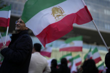 Demonštranti mávajú vlajkami počas pochodu za solidaritu s iránskymi ženami. FOTO: TASR/AP