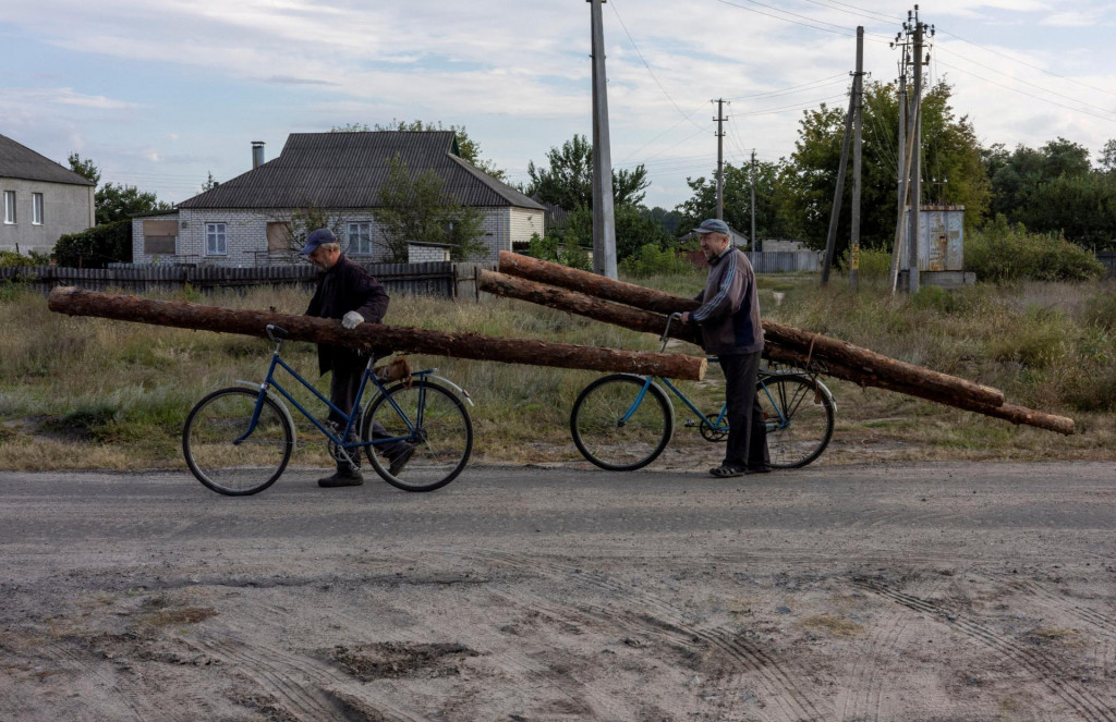 Muži s drevom na bicykli. FOTO: Reuters