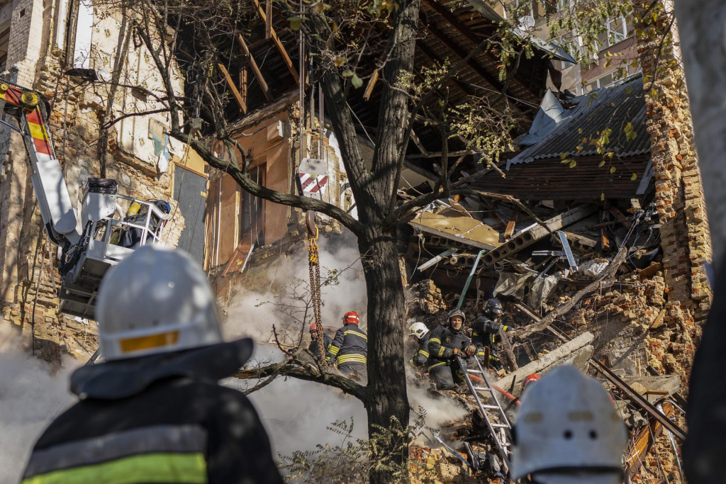 Hasiči zasahujú na mieste útoku dronov na budovy v ukrajinskej metropole Kyjev počas ruskej vojny na Ukrajine. FOTO TASR/AP
