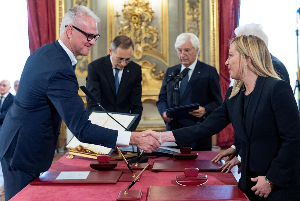 Taliansky minister verejnej spr&aacute;vy bez portf&oacute;lia Paolo Zangrillo si pod&aacute;va ruku s novou talianskou premi&eacute;rkou Giorgiou Meloniovou počas sl&aacute;vnostnej pr&iacute;sahy v prezidentskom pal&aacute;ci Quirinale v R&iacute;me. FOTO: REUTERS