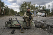 Ukrajinský vojak fajčí cigaretu po tom, ako našiel a identifikoval mŕtve telo kamaráta. FOTO: TASR/AP