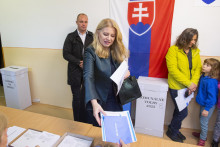 Prezidentka Zuzana Čaputová si preberá hlasovacie lístky od členky volebnej komisie vo volebnej miestnosti. FOTO: TASR/Michal Svítok