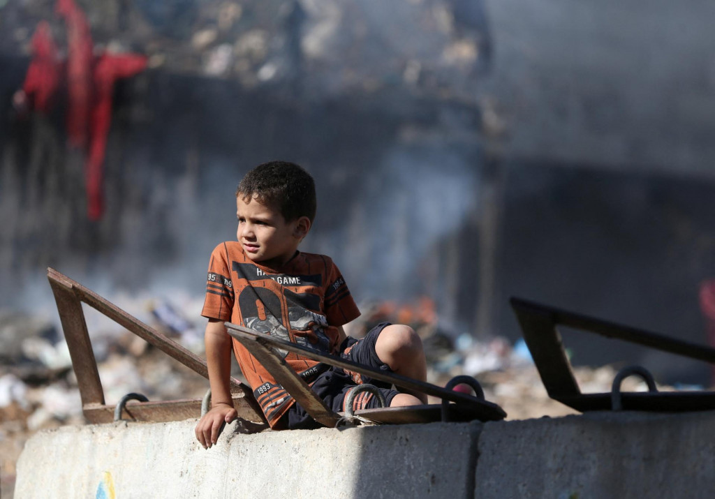 

Palestínske dieťa sedí na stene v Khan Younis v južnom pásme Gazy. FOTO: Reuters