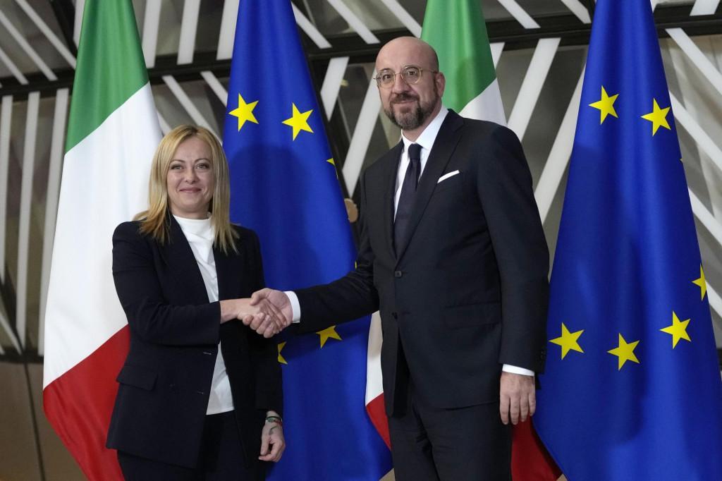 Predseda Európskej rady Charles Michel (vpravo) a talianska premiérka Giorgia Meloniová si podávajú ruky v Bruseli. FOTO: TASR/AP