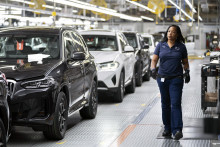 Zamestnankyňa kráča vo výrobnom závode automobilky BMW. FOTO: TASR/AP