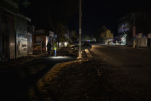 Ľudia kráčajú po tmavej ulici počas výpadku elektriny v meste Boroďanka na predmestí Kyjeva. FOTO: TASR/AP