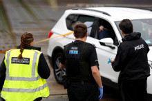 

Imigrační a policajní dôstojníci stoja vedľa auta, o ktorom sa predpokladá, že bolo použité pri útoku benzínovou bombou na spracovateľské stredisko hraničných síl v Doveri. FOTO: Reuters