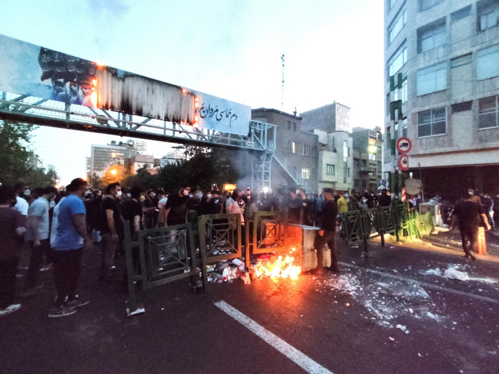 Ľudia zapaľujú oheň počas protestu po smrti Mahsi Amíníovej. FOTO: Reuters