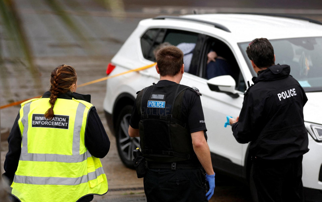 

Imigrační a policajní dôstojníci stoja vedľa auta, o ktorom sa predpokladá, že bolo použité pri útoku benzínovou bombou na spracovateľské stredisko hraničných síl v Doveri. FOTO: Reuters
