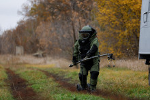 Príslušník ukrajinských ozbrojených síl v ochrannom výstroji demonštruje používanie zariadenia na detekciu mín na poli uprostred ruskej invázie. FOTO: REUTERS