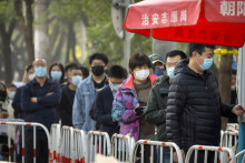 Ľudia s ochrannými rúškami na tvári proti šíreniu COVID-19 čakajú v rade na koronavírusový test v Pekingu. FOTO TASR/AP