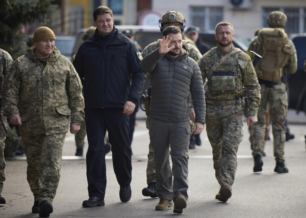 Ukrajinský prezident Volodymyr Zelenskyj (uprostred) máva počas návštevy v oslobodenom meste Cherson na juhu Ukrajiny. FOTO: TASR/AP