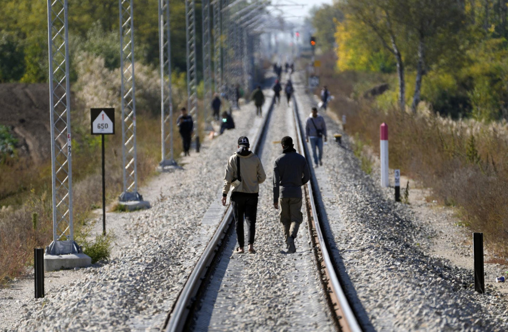 Migranti kráčajú po železničnej trati v obci Horgoš na severe Srbska pri hraniciach s Maďarskom. FOTO: TASR/AP