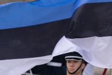 Člen čestnej stráže stojí pri estónskej vlajke. FOTO: TASR/AP
