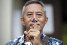 Volič ukazuje označený zafarbený prst po hlasovaní počas predčasných volieb do 222-člennej dolnej komory parlamentu v metropole Malajzie Kuala Lumpure. FOTO: TASR/AP