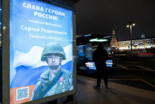 Na autobusovej zastávke vidno tabuľu s vyobrazením ruského služobníka Sergeja Reštnikova so sloganom „Sláva hrdinom Ruska“ v Moskve. FOTO: REUTERS