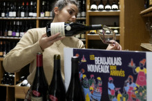 Na snímke žena nalieva víno Beaujolais Nouveau v reštaurácii Les Enfants du Marché v Paríži vo štvrtok 17. novembra 2022. FOTO: Reuters