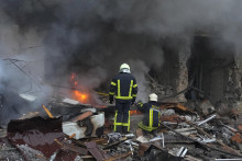 Hasiči hasia požiar na obytnej budove po ruskom raketovom útoku v Kyjeve. FOTO: TASR/AP