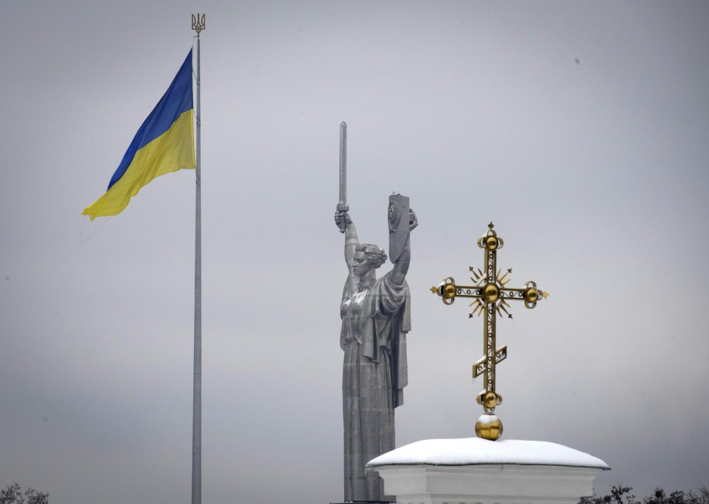 Ukrajinská vlajka, pamätník Veľkej vlasteneckej vojny a kríž v Kyjeve. FOTO: TASR/AP
