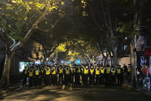Čínski policajti blokujú miesto, kde sa zhromažďujú demonštranti počas protestu proti covidovým opatreniam v čínskom Šanghaji 27. novembra 2022. FOTO: TASR/AP