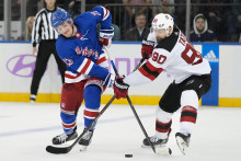 Slovenský hokejista v drese New Jersey Devils Tomáš Tatar (vpravo) a obranca New Yorku Rangers Adam Fox bojujú o puk v zápase zámorskej hokejovej NHL. FOTO: TASR/AP