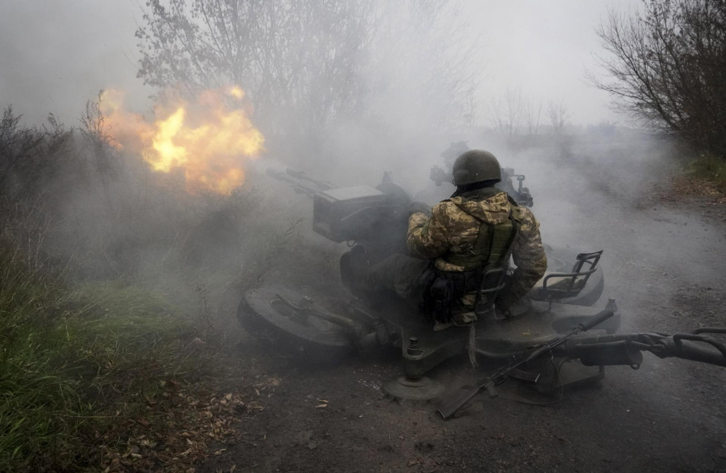 Príslušníci ukrajinskej Národnej gardy ostreľujú ruské pozície z protilietadlového dela v Charkovskej oblasti.  FOTO: TASR/AP
