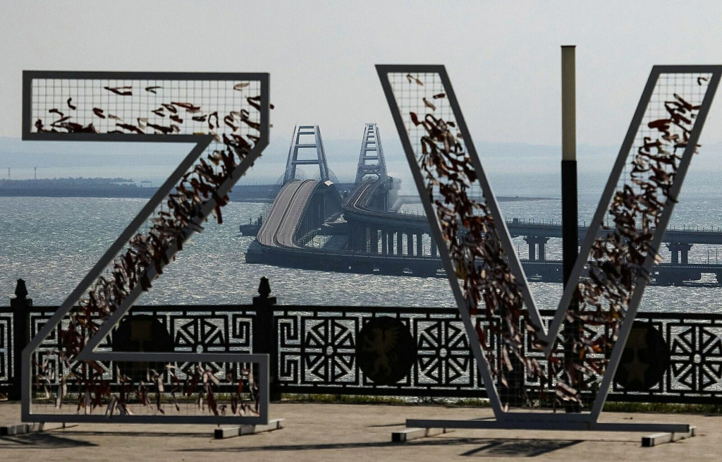 Symbolické písmená „Z“ a „V“ reprezentujúce ruské ozbrojené sily na Ukrajine sú vidieť na pozadí Kerčského mosta, ktorý bol ťažko poškodený výbuchom. FOTO: Reuters