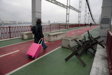 Žena kráča na moste cez rieku Dneper v Kyjeve. FOTO: TASR/AP