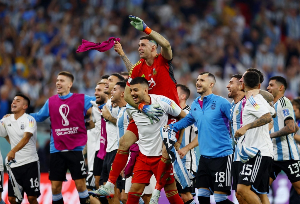 Argentínčania Emiliano Martinez a Franco Armani oslavujú po zápase so spoluhráčmi postup Argentíny do štvrťfinále. FOTO: Reuters