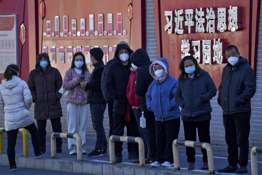 Ľudia v ochranných rúškach čakajú v rade na testovanie na ochorenie COVID-19 v Pekingu. FOTO: TASR/AP
