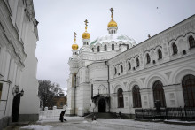 Žena odhrabáva sneh na území pravoslávneho kláštora Kyjevsko-pečerská lavra v Kyjeve. FOTO: TASR/AP
