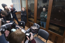 Opozičný politik Iľja Jašin (v pozadí vpravo) v cele súdnej siene počas pojednávania v Moskve. FOTO: TASR/AP