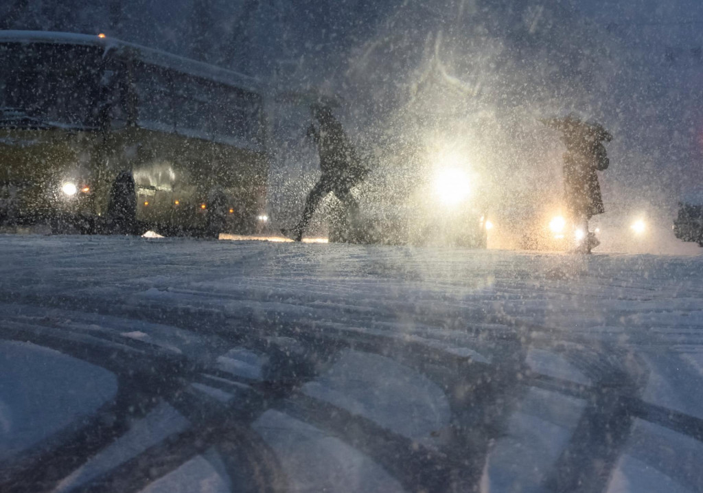 People cross the street amid snowfall as Russia&lsquo;s invasion of Ukraine continues, in central Kyiv, Ukraine December 12, 2022. REUTERS/Gleb Garanich SN&Iacute;MKA: Gleb Garanich