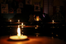 

Ľudia sedia v krčme osvetlenej sviečkami počas výpadku elektriny po tom, čo kritickú civilnú infraštruktúru zasiahli ruské raketové útoky. FOTO: Reuters